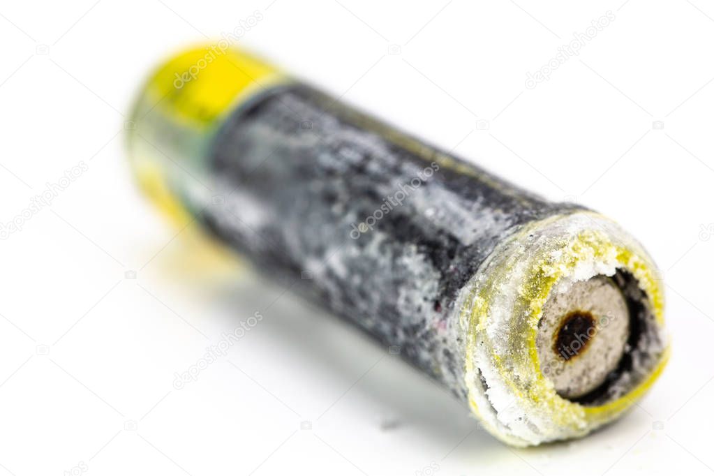 The old battery was leaking hazardous waste. Isolated background. Alkaline batterie.
