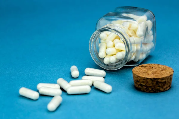 Close Overturned Pills Glass Jar Blue Colored Background — Stock Photo, Image