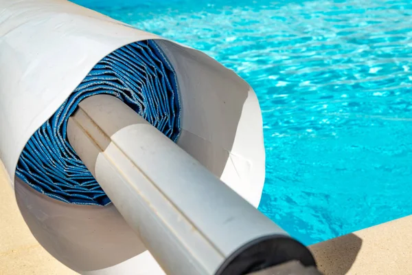 closeup on a pool cover on the edge of a pool during the summer