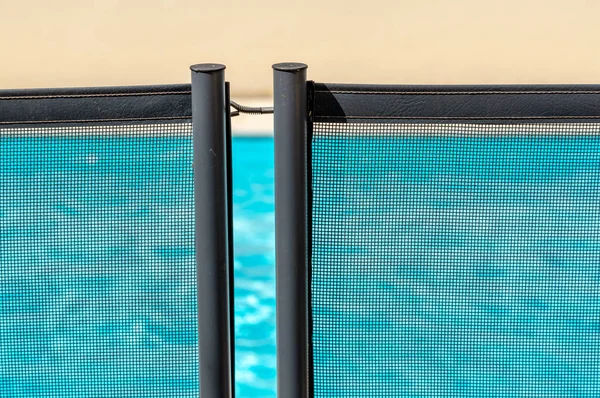 View of a pool through a mandatory safety net on the edges of a private psicine