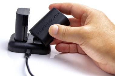 Adam kamera batarya ve þarj cihazý beyaz arka planda işleme