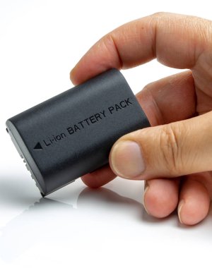 Adam beyaz arka plan üzerinde fotoğraf makinesi pili değiştirme