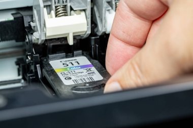 Benon, Fransa - 15 Ocak 2019: Bir adam bir mürekkep püskürtmeli yazıcı üzerinde bir el tarafından Canon 511 renkli mürekkep kartuş yedek kartuşları kapat