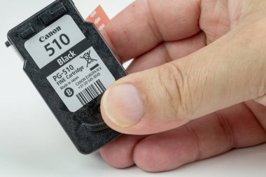Benon, Fransa - 15 Ocak 2019: koruyucu film beyaz arka plan üzerinde izole ile adam elinde tutan Canon 510 (siyah) mürekkep püskürtmeli kartuş