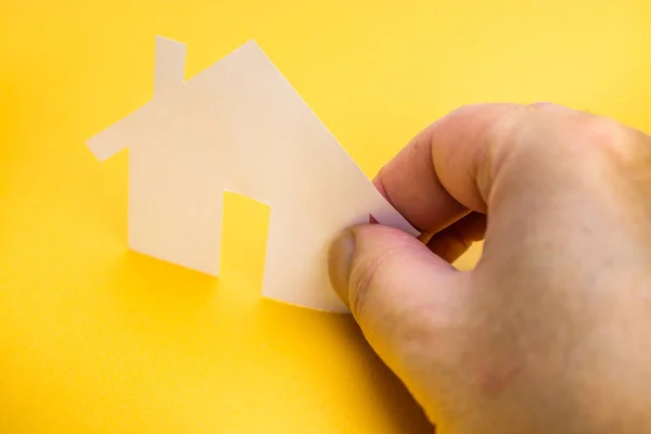 Hand Som Håller Ett Papper Hus Gul Bakgrund Fastigheter Konceptet — Stockfoto