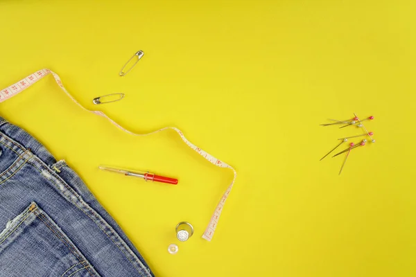 Multiple accessories for sewing view from above on a yellow background. clothing manufacturing concept, retouching, repair, fashion design, passion or fashion trade