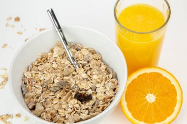 Delicious balanced breakfast with a bowl of muesli and fresh orange juice