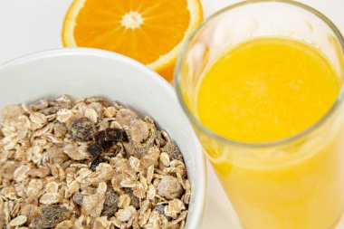 Delicious balanced breakfast with a bowl of muesli and fresh orange juice