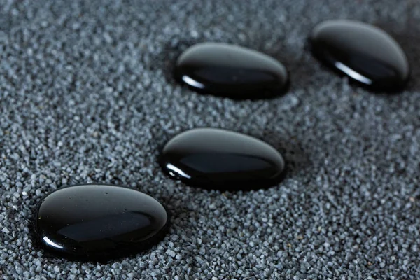 Zen stones with drops of water on a black background