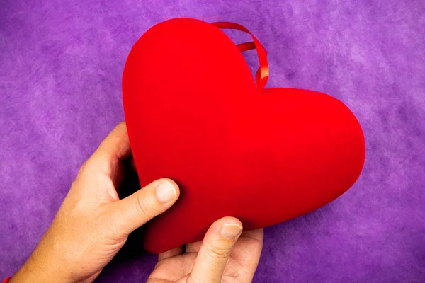 Mão Homem Segurando Grande Coração Vermelho Fundo Roxo — Fotografia de Stock