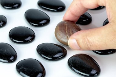 Siyah beyaz arka plan üzerinde kahverengi çakıl ile çakıl taşı. Çeşitlilik veya tekillik kavramı