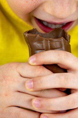 Mutlu genç çocuk çikolata Paskalya tavşanı kulağını ısırıp