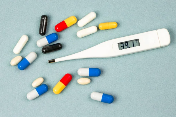 温度計や錠剤は 病気と治療に関連付けます 薬物にある青色の背景との色の変化 — ストック写真