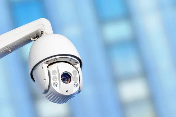 Modern CCTV camera with business buildings in the background — Stock Photo, Image