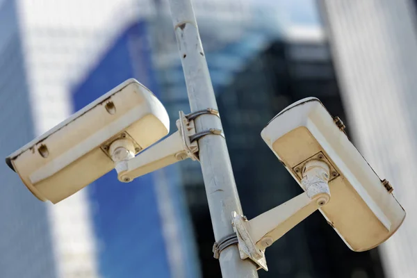 Modern CCTV camera with business buildings in the background — Stock Photo, Image