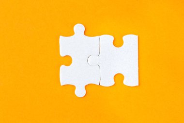 Turuncu zemin üzerine iki bağlı jigsaw puzzle parçaları