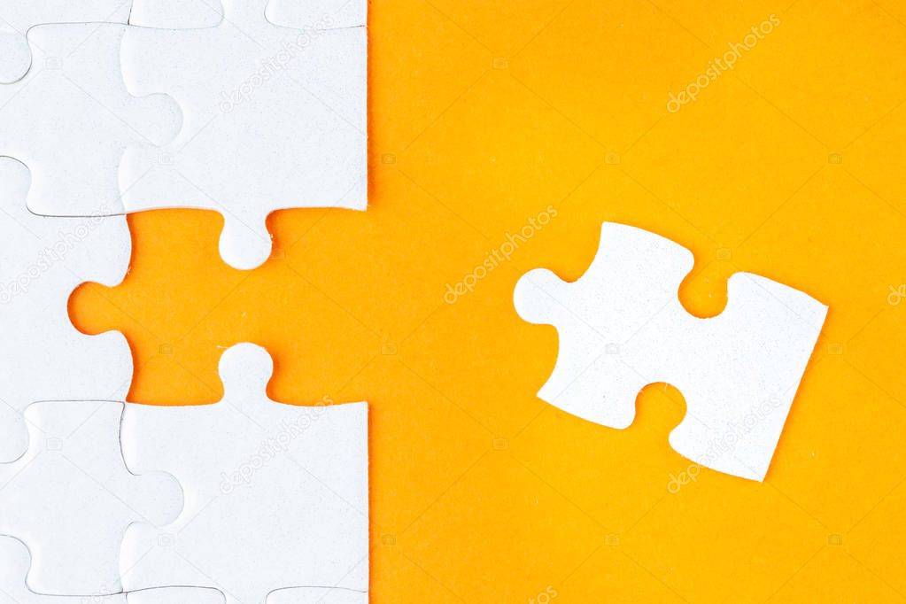 Last jigsaw puzzle pieces on orange background