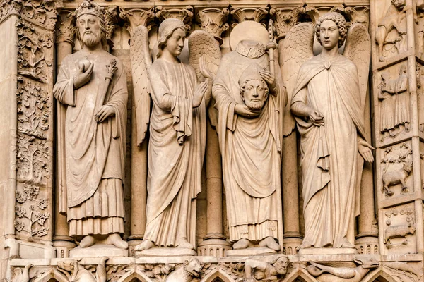 The four large statues of the left-hand side of the portal of Notre dame cathedral — Stock Photo, Image