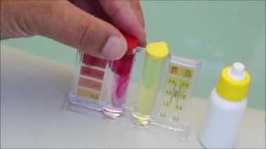 Ph klor ve bromür testi kiti. Test prosedüründe yakın çekim - faz 2 karışımı ve reaktifi sallama