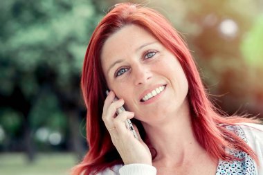 Gülümseyen güzel genç kadın cep telefonu ile yakın, tekrar