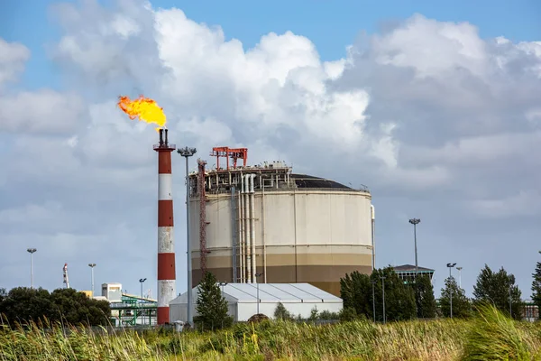 Vista di impianto di raffineria di petrolio con il suo camino fiammeggiante contro il cielo blu — Foto Stock