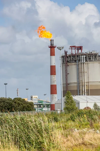 Utsikt över oljeraffinaderiet med sin flammande eldstad mot blå himmel — Stockfoto