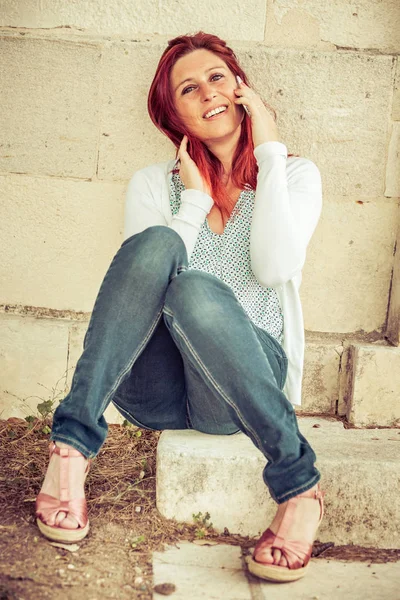 Sevimli gülümseyen kızıl saçlı kadın cep telefonu ile bir arama yapma — Stok fotoğraf