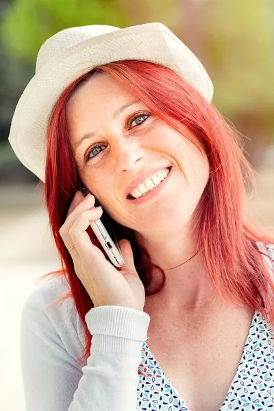 Uśmiechnięta piękna młoda kobieta bliska z telefonem komórkowym, przeciw — Zdjęcie stockowe
