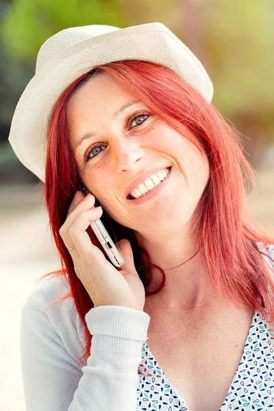 Sonriendo hermosa mujer joven de cerca con el teléfono móvil, agains — Foto de Stock