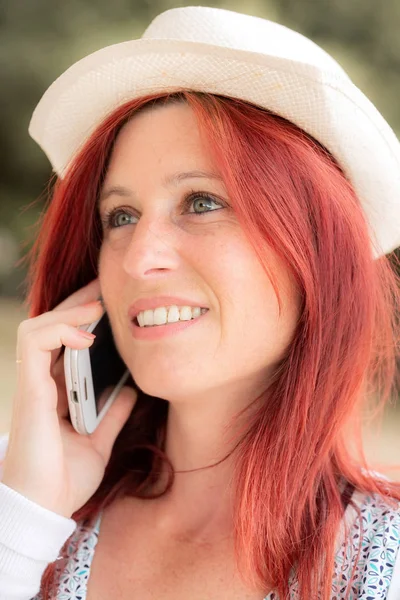 Sonriendo hermosa mujer joven de cerca con el teléfono móvil, agains — Foto de Stock