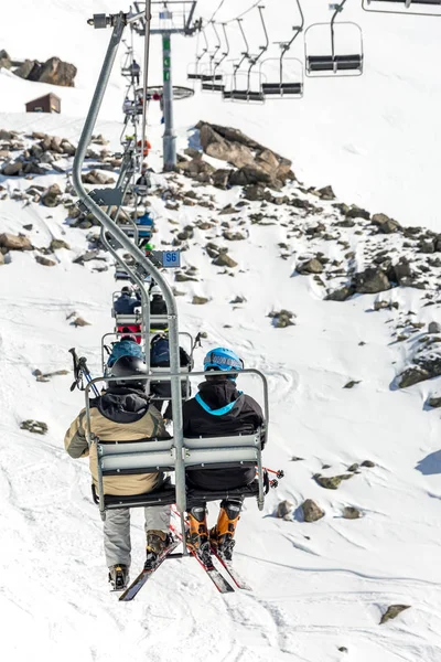 Pessoas irreconhecíveis andando de ropeway sobre encosta de montanha nevada — Fotografia de Stock