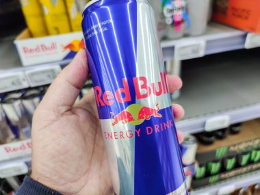 Puilboreau, Fransa - 14 Ekim 2020: Süpermarket raflarında satılmak üzere Red Bull Enerji İçeceği Kutusu 'nu satın alan adamın yakın çekimi. Red Bull dünyadaki en popüler enerji içeceğidir.