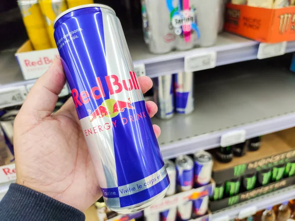 Puilboreau, Fransa - 14 Ekim 2020: Süpermarket raflarında satılmak üzere Red Bull Enerji İçeceği Kutusu 'nu satın alan adamın yakın çekimi. Red Bull dünyadaki en popüler enerji içeceğidir.