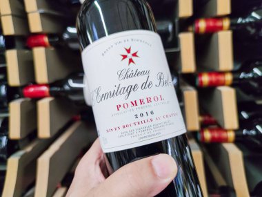 Builboreau, Fransa - 14 Ekim 2020: Man 'in Kapanışı Pomerol Sınıflandırılmış büyüme şişesi alıyor, süpermarkette harika bir Fransız Bordeaux şarabı