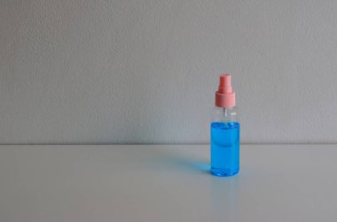 Çimento duvarına karşı ahşap masaya konmuş mavi renkli el dezenfektanı. İnsanlar koronavirüs salgınından dolayı sık sık ellerini temizlemek zorundalar.