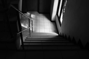 Merdiven boşluğunun yüksek açılı görüntüsü bir binanın koridorunda, siyah beyaz görüntü. 