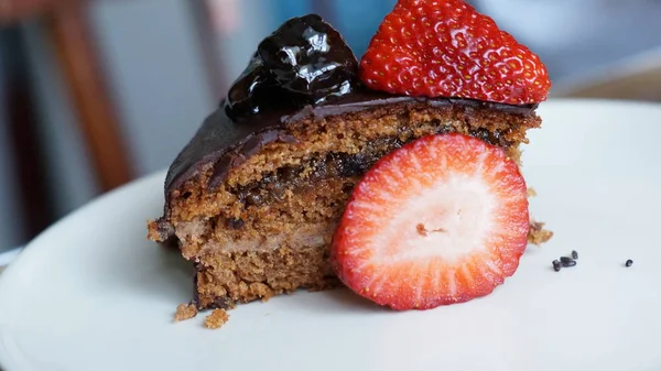 Bir parça bir plaka üzerinde çilek ile çikolatalı kek