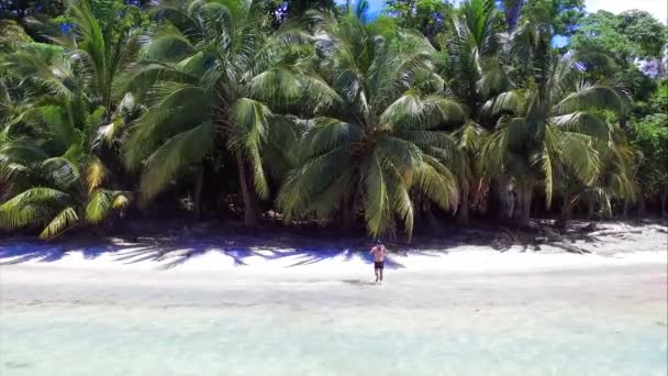 Jeune homme plongeant dans les eaux cristallines du sable blanc de la plage. Drone aérien d'un jeune homme faisant de la plongée avec tuba dans la mer des Caraïbes. Plages vierges de Carenero dans les îles de Bocas del Toro dans le parc marin national de l'Isla Bastimentos au Panama 