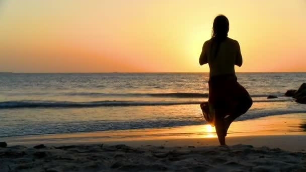 年轻人在海边练习放松运动 海上金色夕阳练习瑜伽 夕阳在海滩上沉思在太阳前 — 图库视频影像