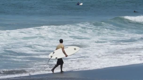 Jonge Surfer Loopt Het Strand Met Zijn Surfplank Onder Zijn — Stockvideo