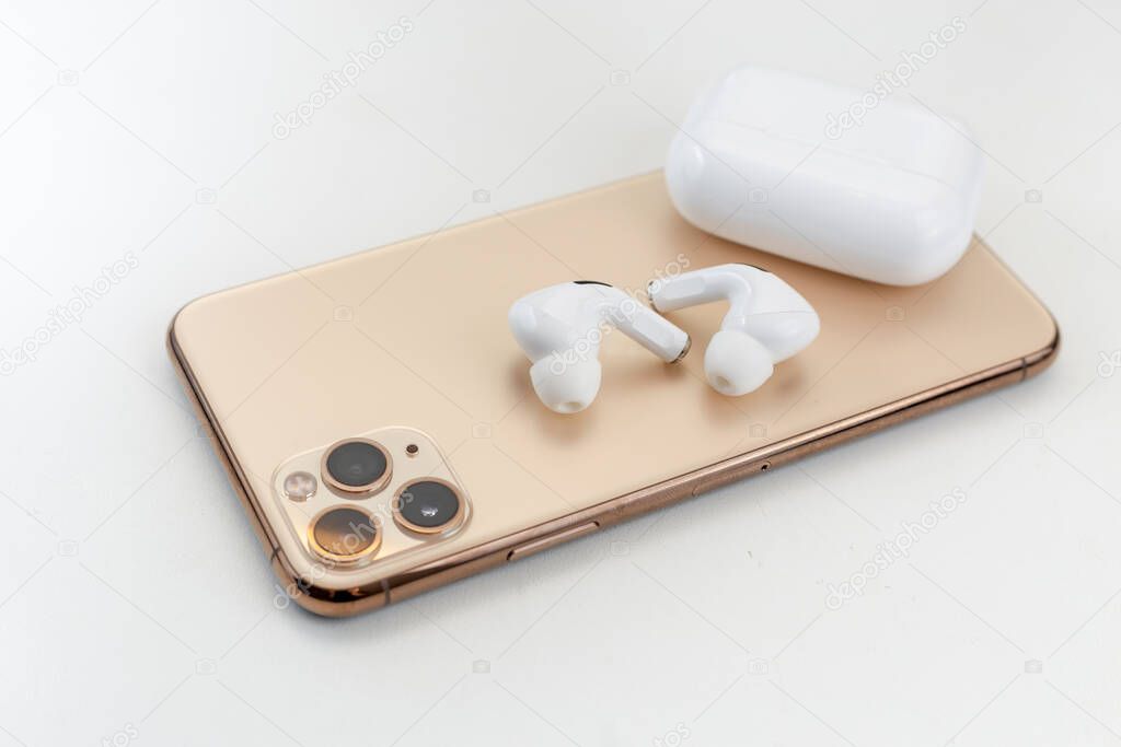 white wireless headphones next to a mobile phone