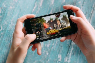 SAINT PETERSBURG, RUSSIA - 5 Haziran 2020: PUBG oyunu ile akıllı telefonu tutan eller