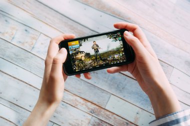 SAINT PETERSBURG, RUSSIA - 5 Haziran 2020: PUBG oyunu ile akıllı telefonu tutan eller