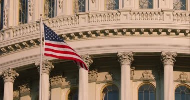 Washington DC 'deki Capitol binasının önünden Amerikan bayrağı geçiyor.