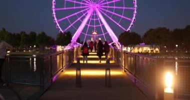 Montreal Kanada limanındaki dönme dolabın yanındaki insanlar.