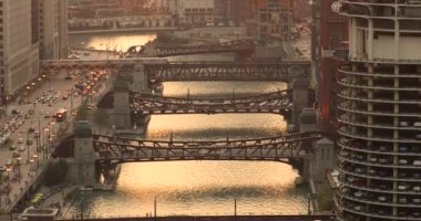 Gün batımında Şikago şehri ve nehir üzerindeki köprüler