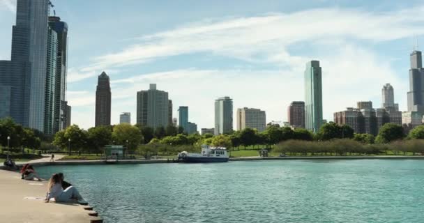 Gente en un parque junto al horizonte de Chicago Illinois — Vídeo de stock