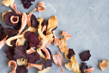 Gri arka plan, kopya alanı üzerinde çeşitli sebze cips. Çeşitli kurutulmuş pancar, havuç, kabak sebze cips - sağlıklı vegan snack.