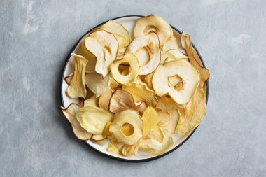 Gri arka plan, kopya alanı üzerinde çeşitli meyve cips. Karışık kurutulmuş elma, armut, kavun, mango meyve cips - sağlıklı vegan snack.