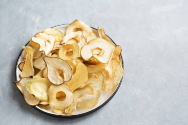 Gri arka plan, kopya alanı üzerinde çeşitli meyve cips. Karışık kurutulmuş elma, armut, kavun, mango meyve cips - sağlıklı vegan snack.